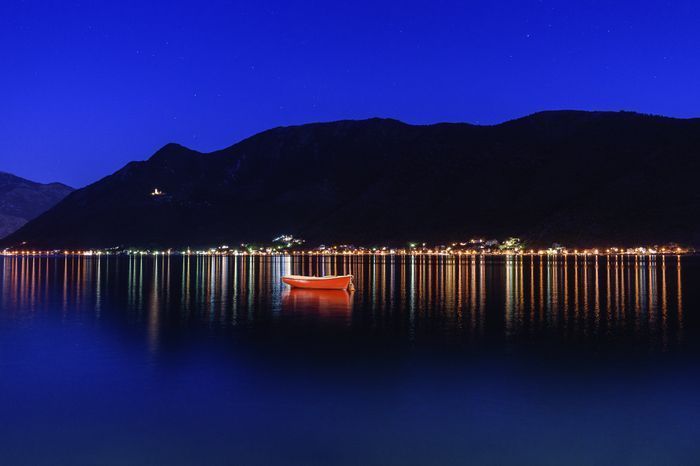 Photo of Sunset over Kotor Bay, with the lit-up church on the hill in the background. Photo of Sunset over Kotor Bay, with the lit-up church on the hill in the background.